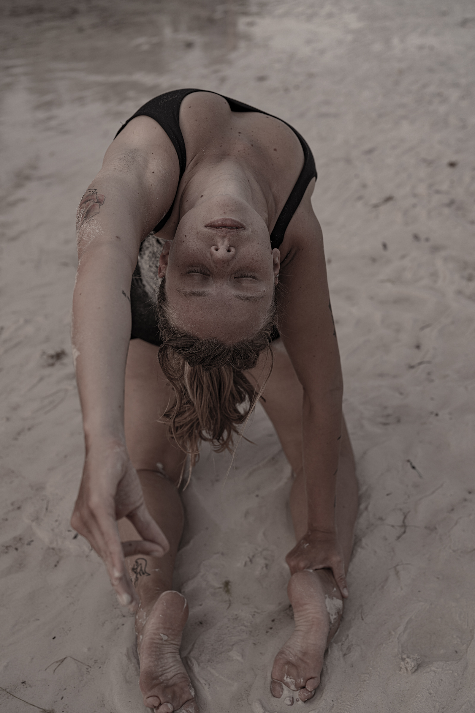 Lisa in a backbend pose on the beach, expressing strength and grace