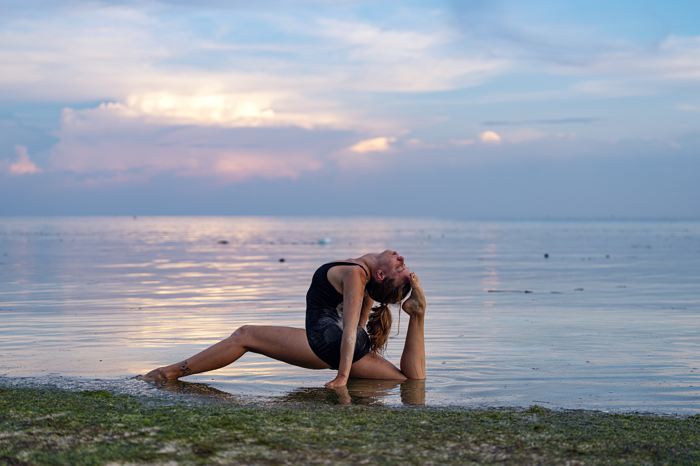 Lisa practicing by the ocean at sunset — open backbend over water